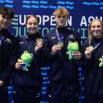 students holding medals and toy frogs