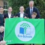 students and teacher holding an eco-schools flag