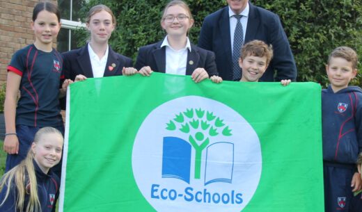 students and teacher holding an eco-schools flag